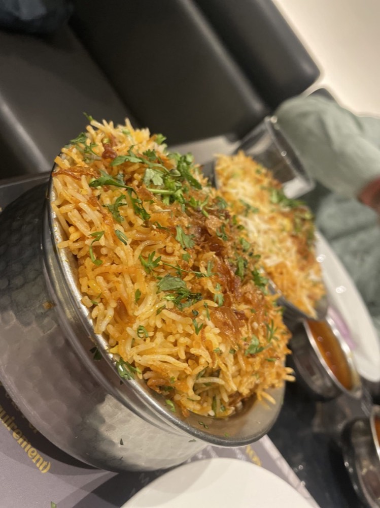 An ordinary phone photo of biryani in a steel bowl